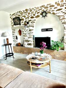 a living room with a stone fireplace and a table at Appartement cosy in Saint-Hilaire-de-Brethmas +7 photos