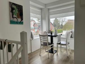 a dining room with a table and chairs and a window at Ferienwohnung M1 in Husby