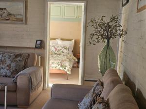 a living room with a couch and a vase of flowers at Queen Anne Cottage in Guildford