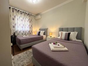 1 dormitorio con 2 camas con sábanas y cortinas moradas en Amy Apartments, en Kassiopi