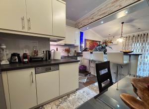 cocina con armarios blancos y comedor en Amy Apartments, en Kassiopi