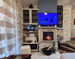 Una sala de estar con chimenea y TV de pantalla plana. en Amy Apartments, en Kassiopi