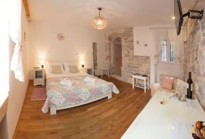 1 dormitorio con cama y pared de piedra en Luxury Room Kokola en Split