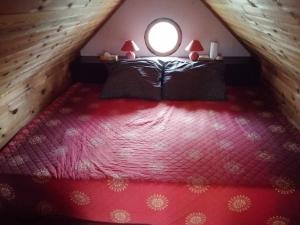 a bedroom with a bed with a round window at Chaloupka Rozmarýna in Srbce