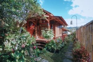 a small wooden house with plants in the yard at Lake Batur Cabin in Kubupenlokan