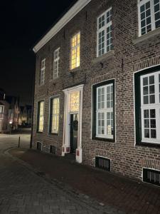 a brick building with lights in the windows at night at Kleiner Marstall in Xanten