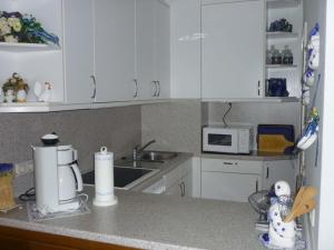 Una cocina con gabinetes blancos y encimera. en FeWo Strandhotel Whg 50 Michalak, en Dahme