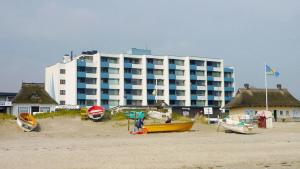 Un gran edificio en la playa con barcos en la arena. en FeWo Strandhotel Whg 50 Michalak, en Dahme