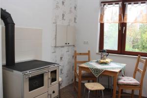 a kitchen with a stove and a table with chairs at Dat Huuske in Gerdau