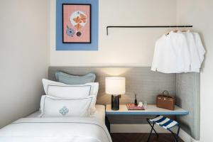 ジャカルタにある2BR Cozy City View CBD Sudirman Park Apartment Positano House Designのベッドとランプ付きのテーブルがある寝室