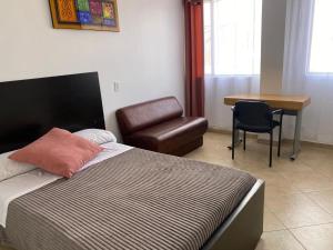 a bedroom with a bed and a chair and a desk at HOTEL Destino Nómada Calle 11 n 1-38 in Bogotá +92 photos