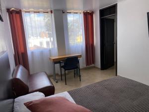 a bedroom with a bed and a desk and windows at HOTEL Destino Nómada Calle 11 n 1-38 in Bogotá