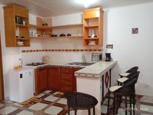a kitchen with wooden cabinets and a white refrigerator at Appartement N01 T3 in Oiapoque