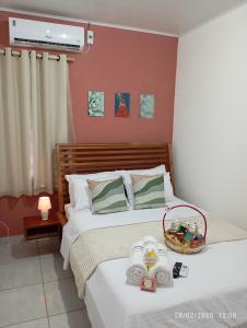 a bedroom with a bed with towels and a basket on it at Appartement N01 T3 in Oiapoque