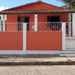a red house with a white fence in front of it at Casa de Temporada Maria Rosa in Piranhas
