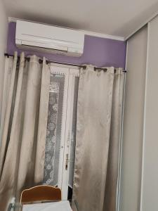 Habitación con ventana con cortinas y calentador en GITE Chez Marilou, en Aulnay-sous-Bois