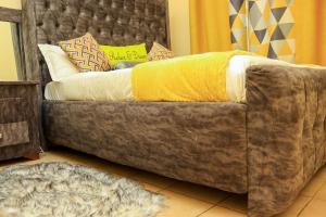 a couch with a yellow blanket on top of it at Sunnyside Apartment in Nairobi