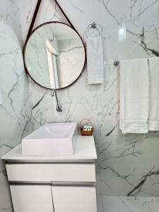 a bathroom with a white sink and a mirror at Centro Expo 25 Shopping Brás Metrô Bom Retiro APT 43 in Sao Paulo