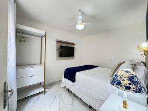 a white bedroom with a bed and a tv at Centro Expo 25 Shopping Brás Metrô Bom Retiro APT 43 in Sao Paulo +22 photos