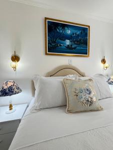 a bedroom with a white bed with a picture on the wall at Centro Expo 25 Shopping Brás Metrô Bom Retiro APT 43 in Sao Paulo