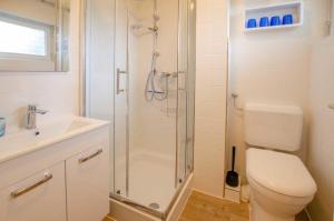 un bagno con doccia, WC e lavandino di FeWo Heimathafen a Kellenhusen