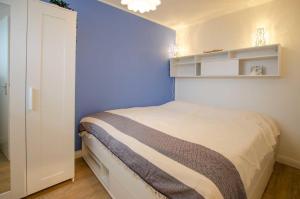 una camera da letto con un letto con una parete blu di FeWo Heimathafen a Kellenhusen Altre 7 foto