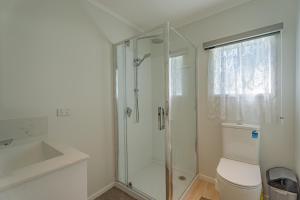 a bathroom with a shower and a toilet and a sink at GeoHaven Rotorua Earths Embrace in Rotorua +54 photos