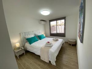 sypialnia z dużym białym łóżkiem i niebieskimi poduszkami w obiekcie Villa Bleue des Sables hypercentre marina plage w mieście Saint-François +15 zdjęć