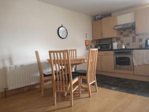 a kitchen with a table and chairs and a clock on the wall at Malone Townhouse in Belfast