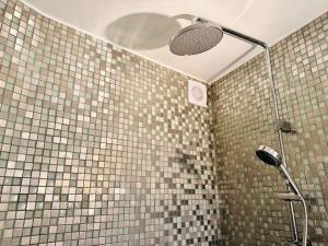 a shower in a bathroom with a tiled wall at Charmant cocon au cœur de Montmartre in Paris +38 photos
