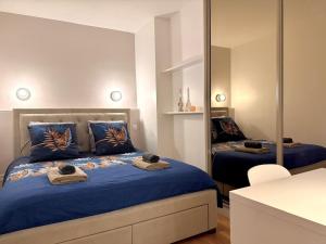 a bedroom with a bed with blue sheets and a mirror at Charmant cocon au cœur de Montmartre in Paris