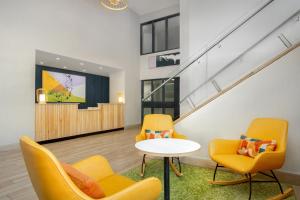 een wachtkamer met gele stoelen en een tafel bij Spark by Hilton Brockville in Brockville