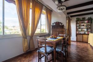 a dining room with a table and some windows at Casa Pittone in Giardini Naxos