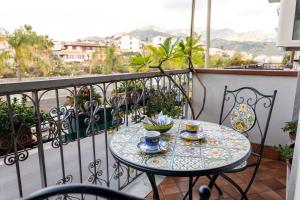 a table with two cups of coffee on a balcony at Casa Pittone in Giardini Naxos