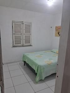a white room with a bed and a window at Kasa Morro Branco in Beberibe