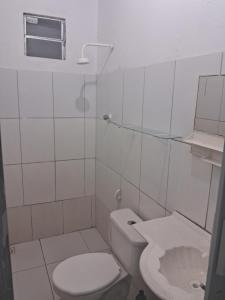 a white bathroom with a toilet and a sink at Kasa Morro Branco in Beberibe +5 photos