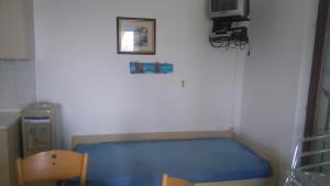 a small bedroom with a blue bed in a room at Apartments Roza in Miškovići