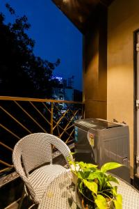 a table and a chair on a balcony at night at Kyomi Service Apartments in Gurgaon