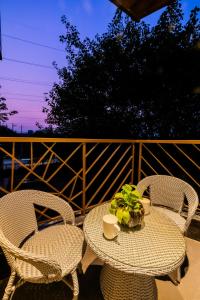 two chairs and a table with a plant on a patio at Kyomi Service Apartments in Gurgaon