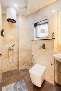 a bathroom with a toilet and a sink at Kyomi Service Apartments in Gurgaon