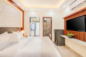 a bedroom with a large bed and a flat screen tv at Kyomi Service Apartments in Gurgaon
