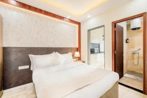 a bedroom with a large bed and a shower at Kyomi Service Apartments in Gurgaon