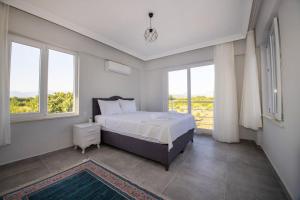 a bedroom with a bed and two windows at Villas Dogakent in Ortaca +62 photos