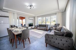 a large living room with a table and chairs at Villas Dogakent in Ortaca