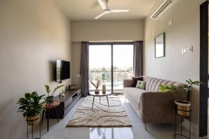 达曼Saavi Suites的带沙发和电视的客厅