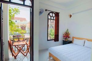 a bedroom with a bed and a view of a balcony at Bong House Homestay in Hoi An