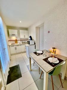 Una cocina con una mesa y sillas en una habitación. en La Côtière, Terrasse et Jardin RDC, Proche plage, en Saint-Palais-sur-Mer 6 fotos más