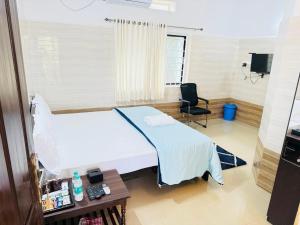 a room with a bed and a desk and a chair at Canara Vibes in Māvalli