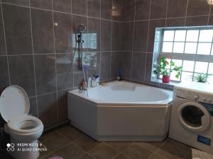 y baño con bañera y lavadora. en GITE Chez Marilou, en Aulnay-sous-Bois