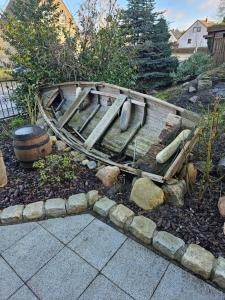 an old wooden boat sitting in a garden at Kapitänshaus - Wolkenstube in Barth +4 photos